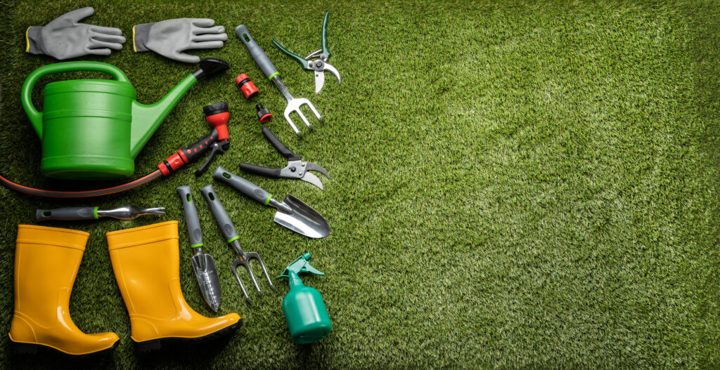 Various Gardening Tools And Boots Laying On Grass